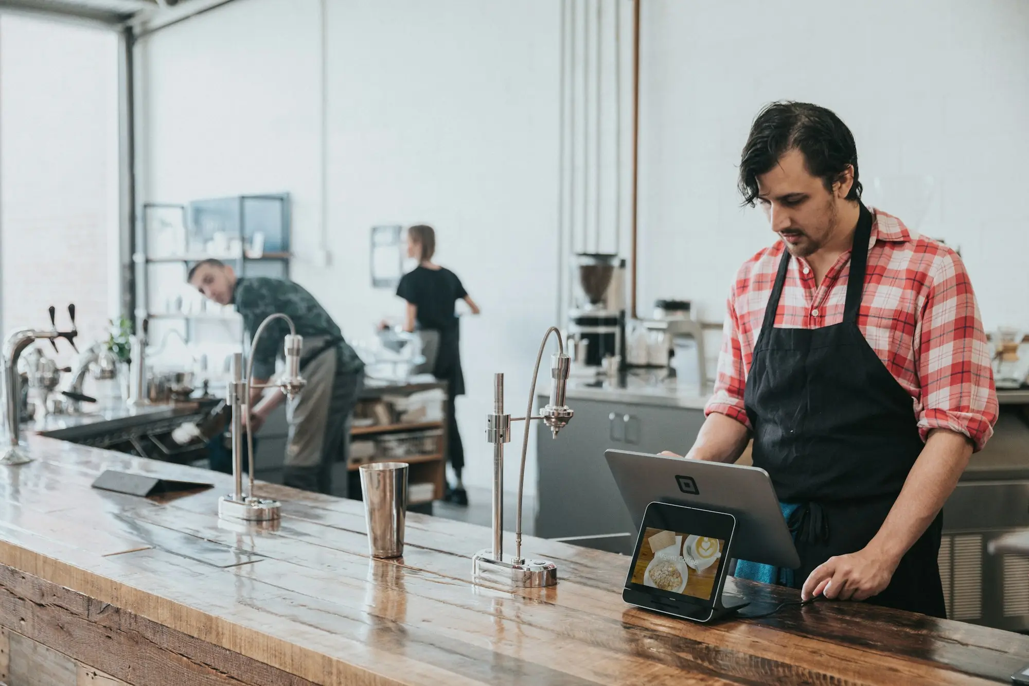 Cafe owner checking accounts on a laptop behind the counter