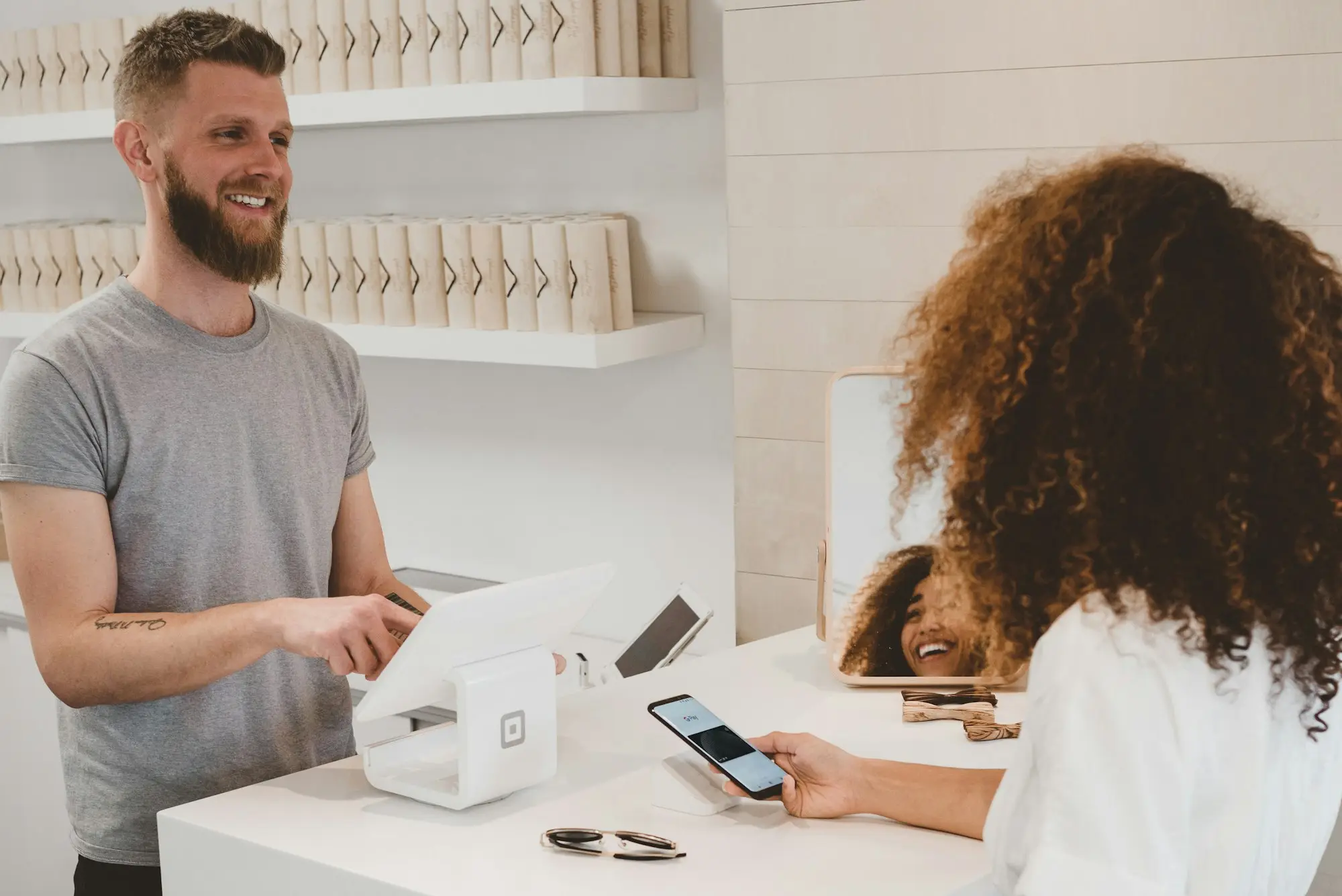 Small shop owner smiling at a customer across the counter