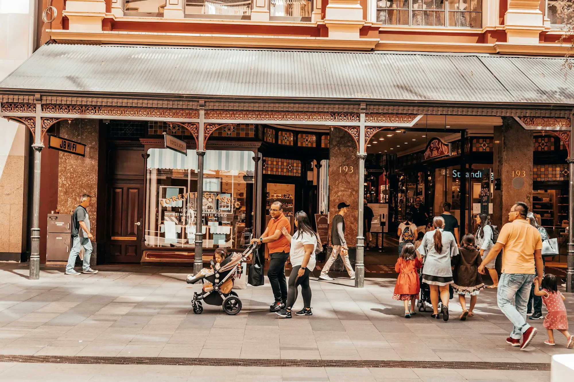 Shoppers walking past verandah shopfronts on a busy main street